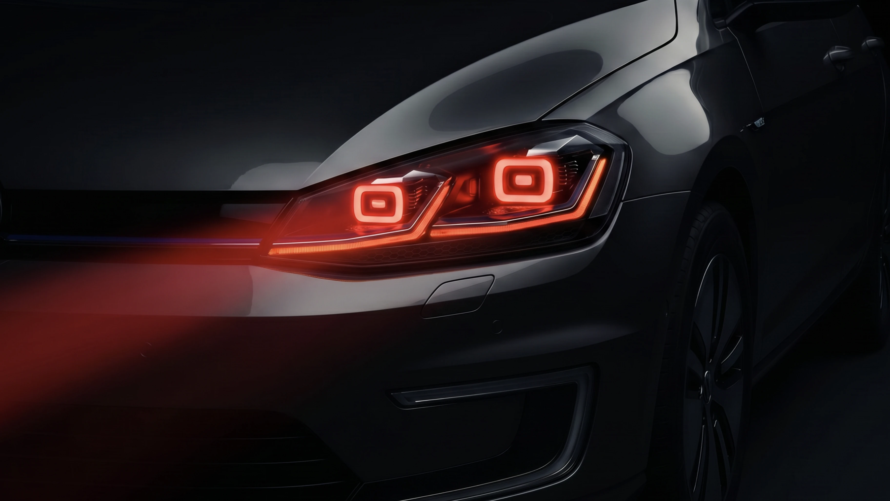 Dark studio photo of a VW Golf rear with glowing red LED ring tail lights — moody automotive photography showcasing the Leds Express product in use